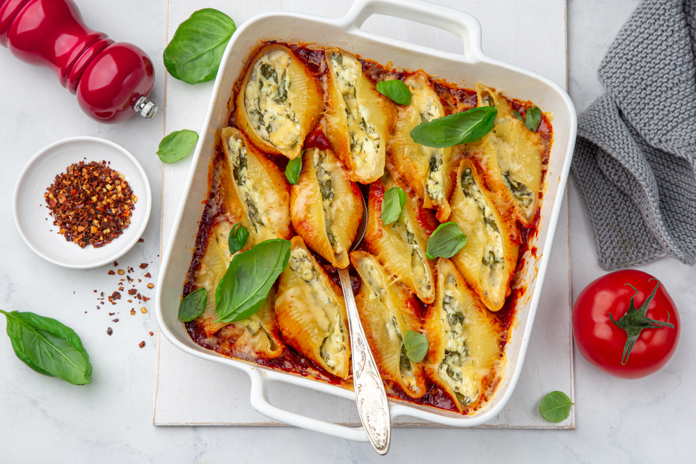 Travessa de conchiglione com creme de ricota e espinafre em cima da mesa