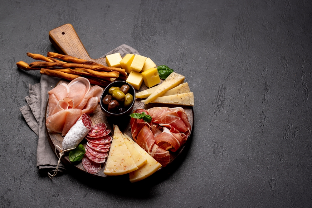 Tábua de frios com queijos, salame, presunto, grissini e azeitona