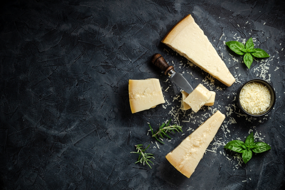 Pedaços de queijo parmesão em peça e ralado