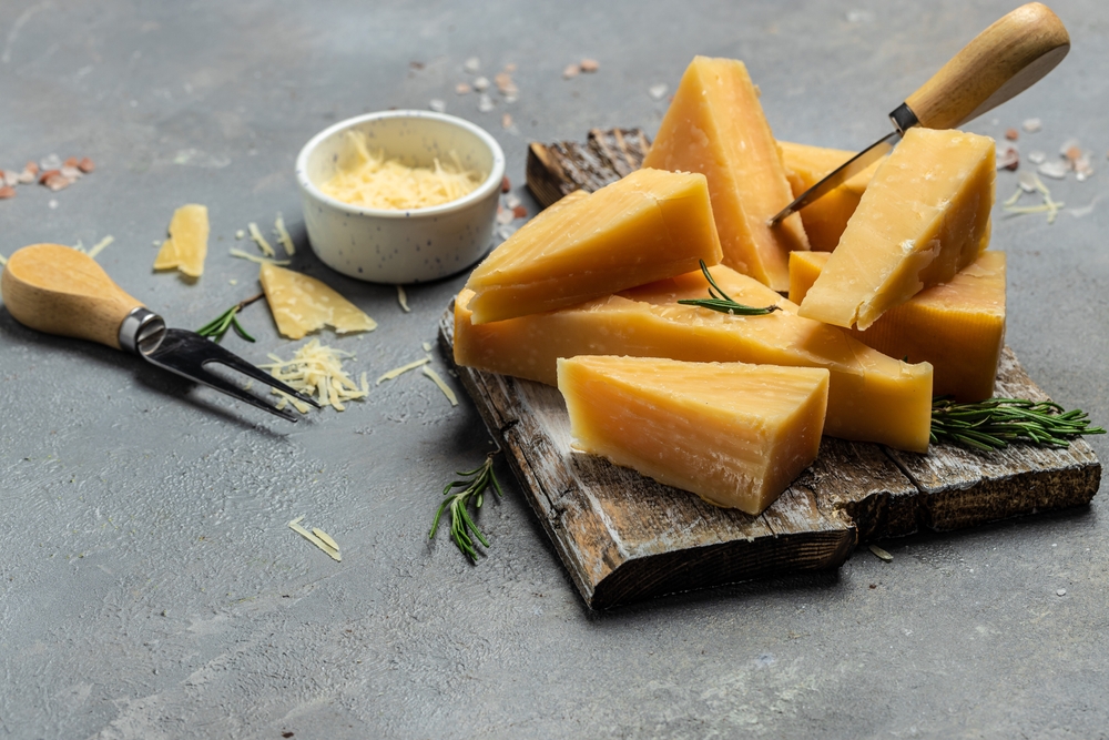 Pedaços de queijo parmesão em tábua de madeira